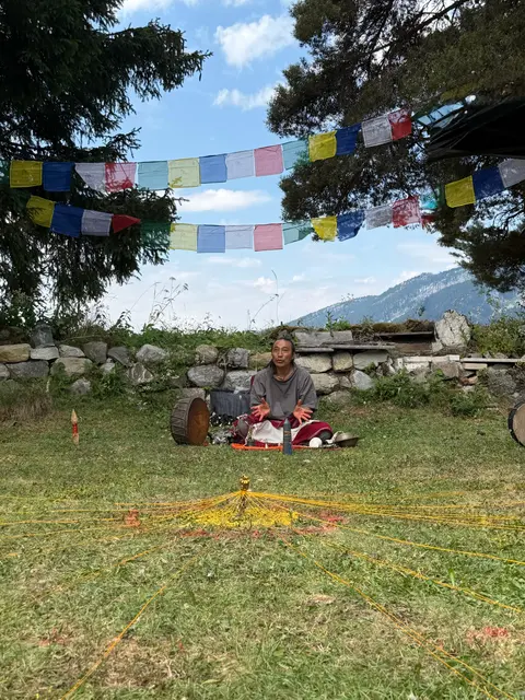Pasang Lama playing between mandala gongs outdoors